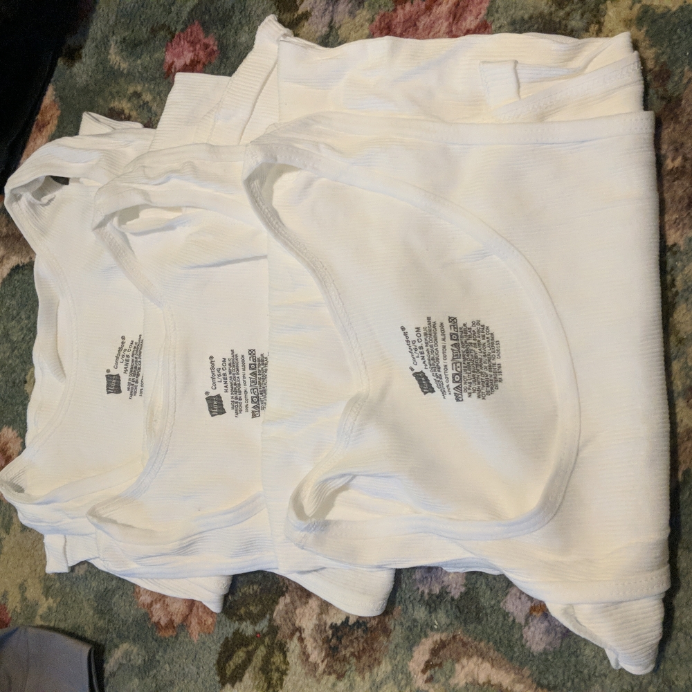 Three white Hanes men's tank tops